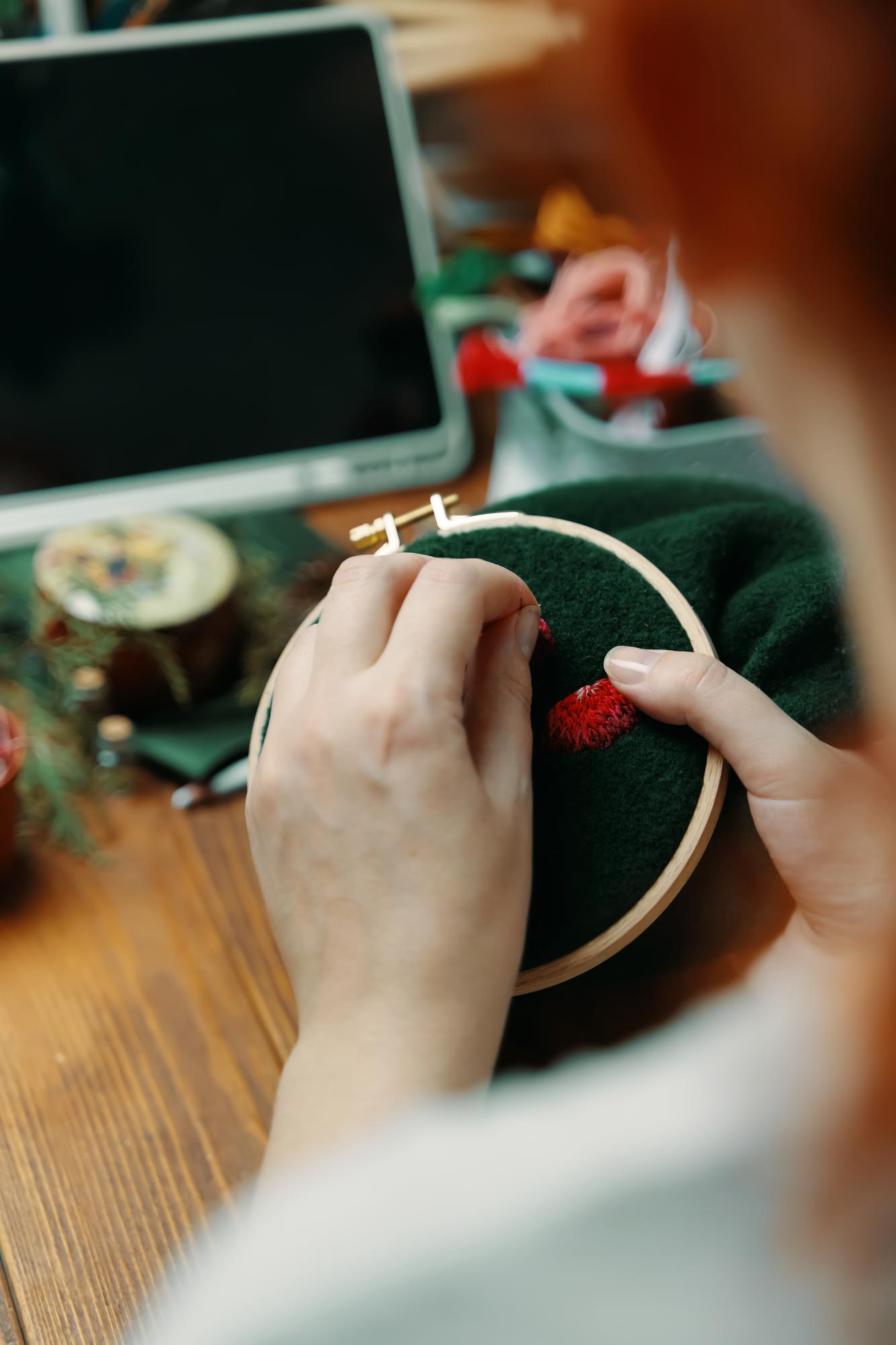 Artist hands embroidering a small motif